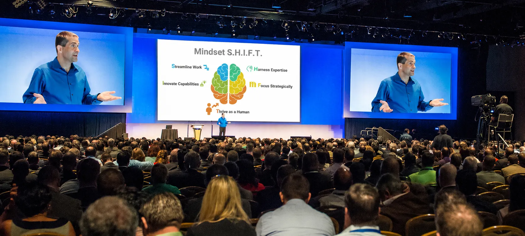 Instructor presenting AI training to a large corporate audience